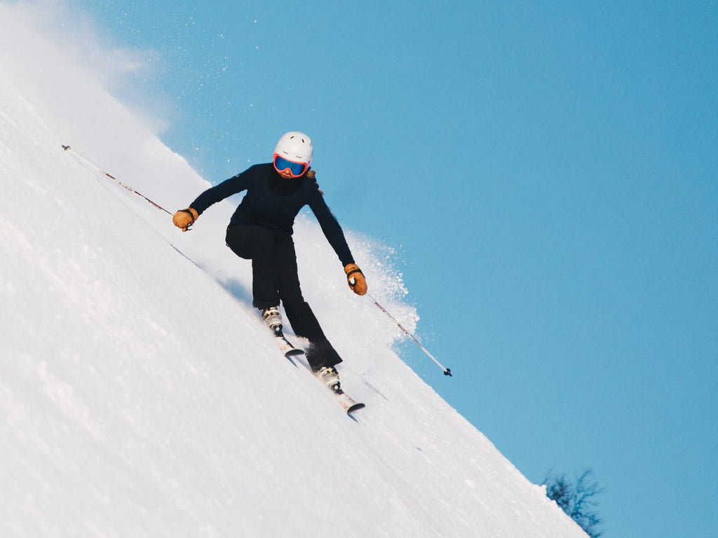 A skiier is skiing down a very steep slope.